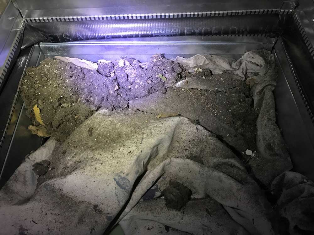 Air duct interior packed with built-up dust and debris before cleaning