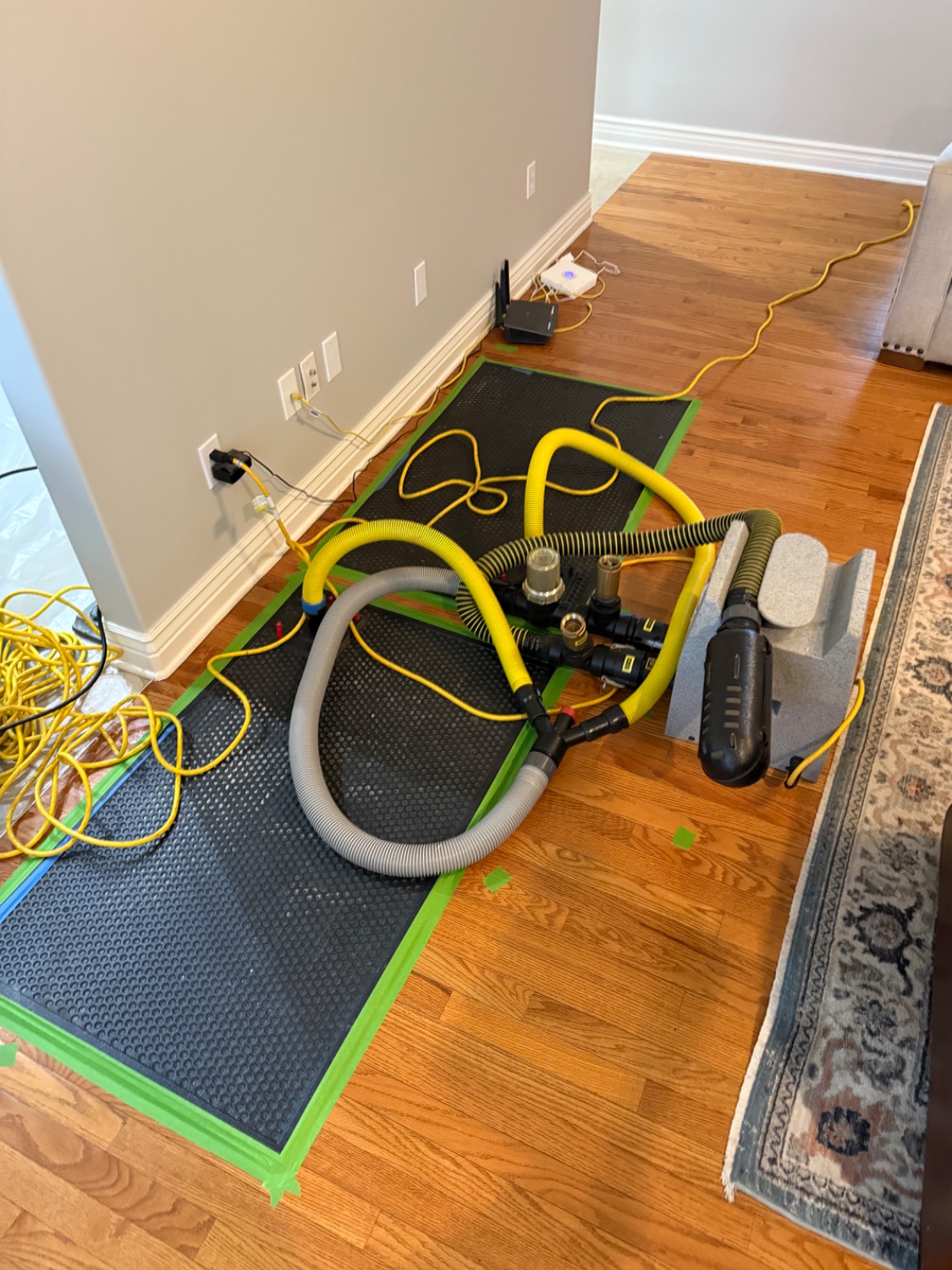 Hardwood floor drying system with hoses and a containment mat